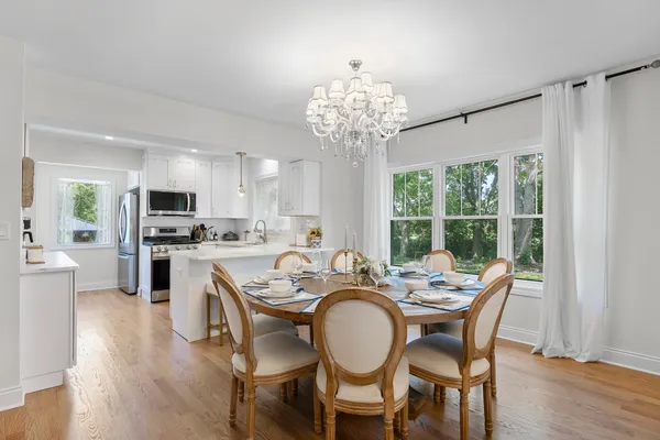 a view of a dining room with furniture a chandelier and wooden floor