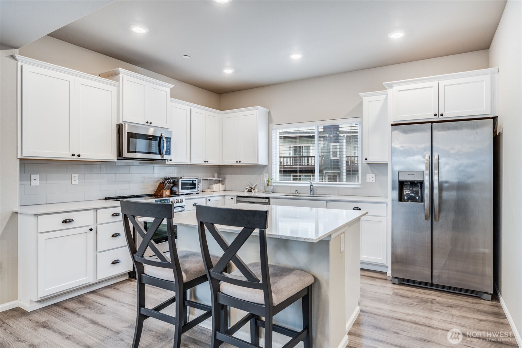 17539 110th Avenue East, Unit H Puyallup, WA 98374 - Photo 11 of 40 a kitchen with a table chairs refrigerator and microwave