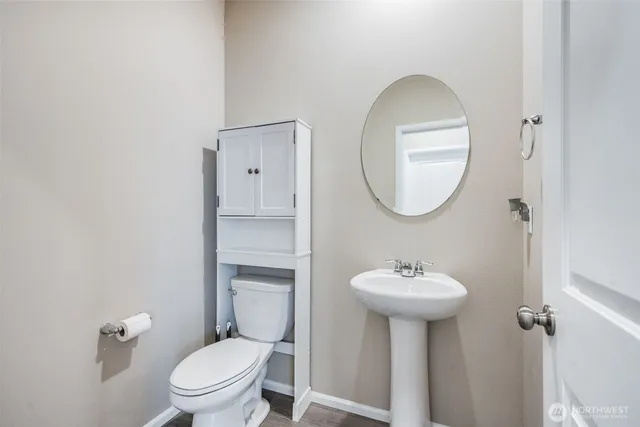 a bathroom with a toilet sink and mirror