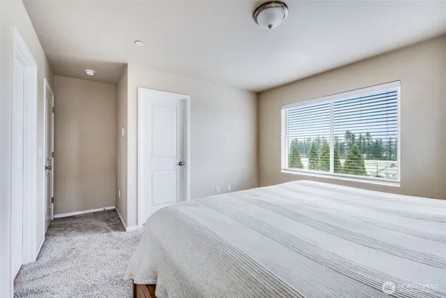a bedroom with a bed and with floor to ceiling window