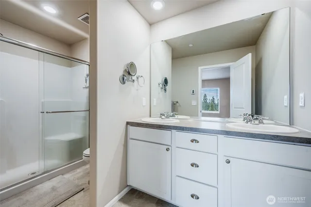 a bathroom with a double vanity sink and mirror