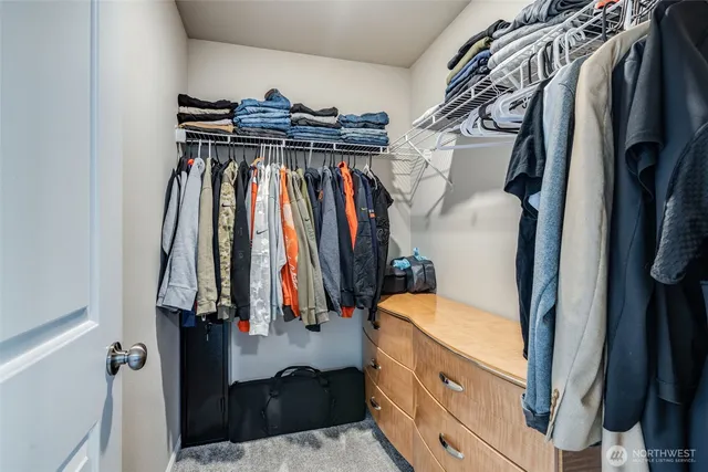 a view of walk in closet with clothes and shoes