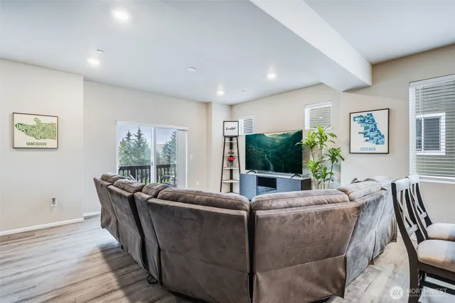 a living room with furniture a flat screen tv and a large window