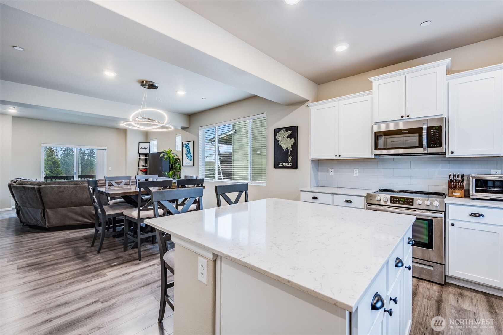 17539 110th Avenue East, Unit H Puyallup, WA 98374 - Photo 7 of 40 a kitchen with stainless steel appliances granite countertop a stove top oven a sink dishwasher a dining table and chairs with wooden floor