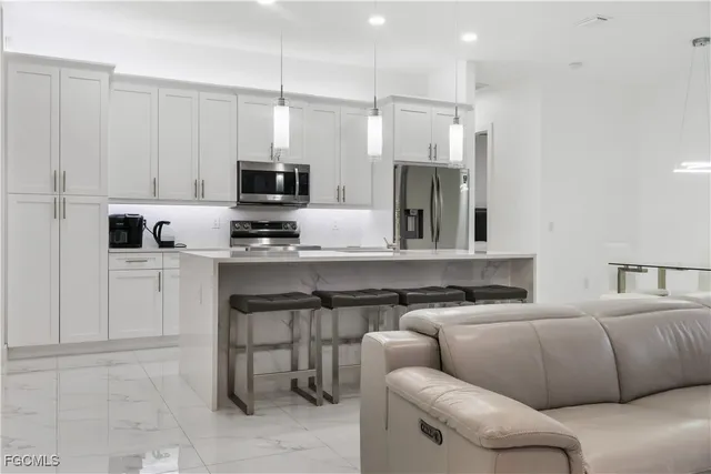 a living room with furniture a flat screen tv and a floor to ceiling window