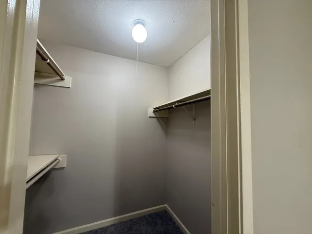 a view of a hallway with wooden shelves