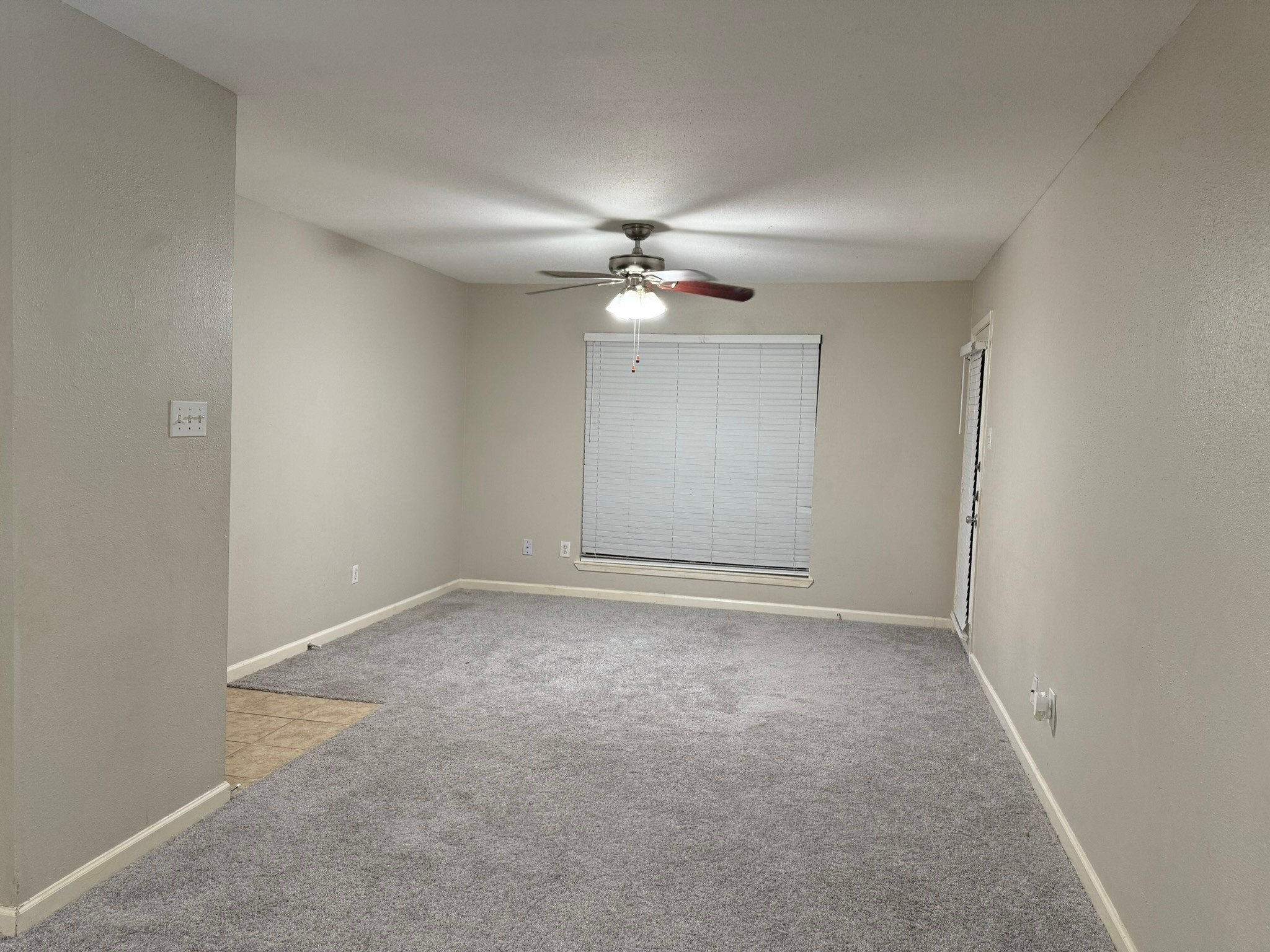 16303 Lyons School Road, Unit 315 Spring, TX 77379 - Photo 4 of 20 an empty room with a chandelier fan and windows