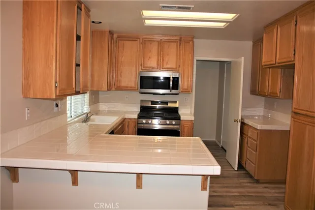 a kitchen with kitchen island a counter space a sink a stove and refrigerator