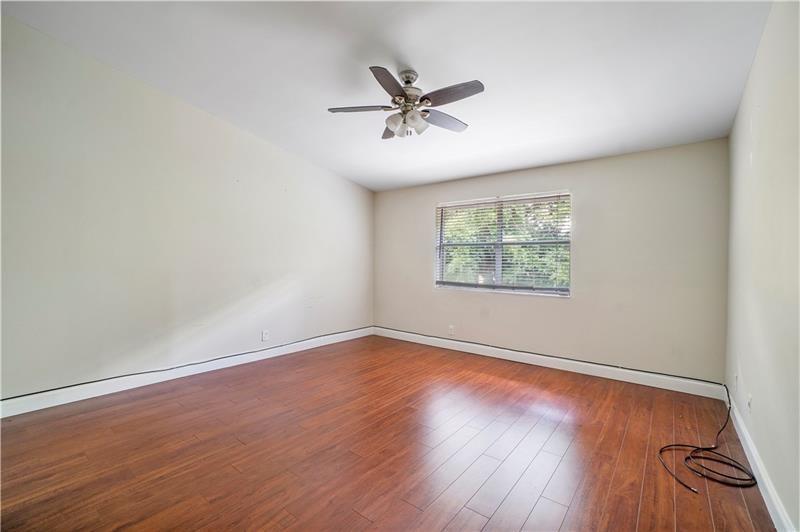 9769 Riverside Drive, Unit 712 Coral Springs, FL 33071 - Photo 11 of 18 an empty room with wooden floor windows and fan
