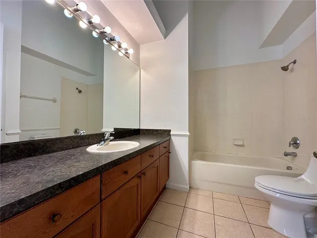a bathroom with a granite countertop sink mirror vanity and toilet