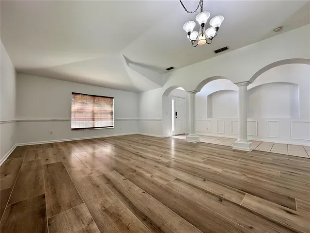 a view of empty room with wooden floor