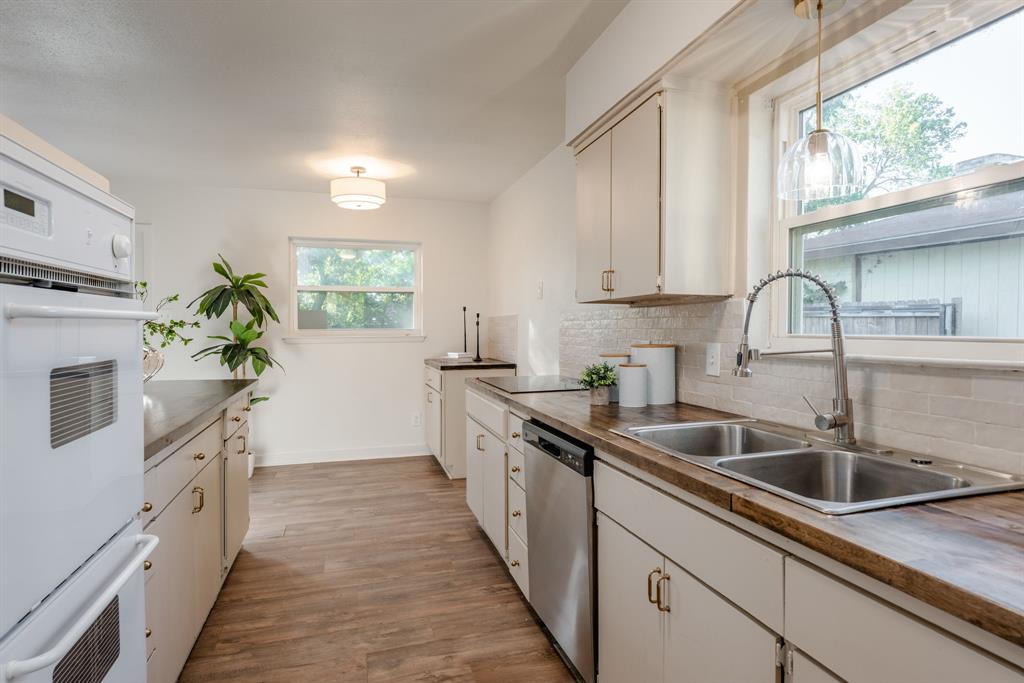 1807 North Waterview Drive Richardson, TX 75080 - Photo 11 of 26 a kitchen with granite countertop a sink stove and cabinets