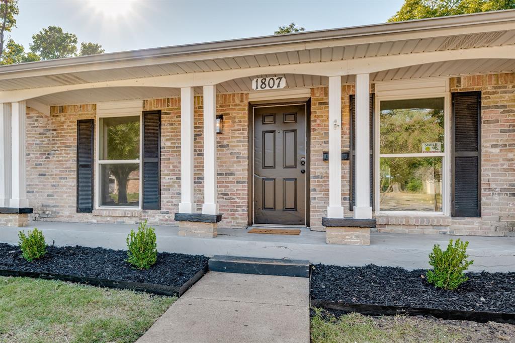 1807 North Waterview Drive Richardson, TX 75080 - Photo 2 of 26 a front view of a house with a yard