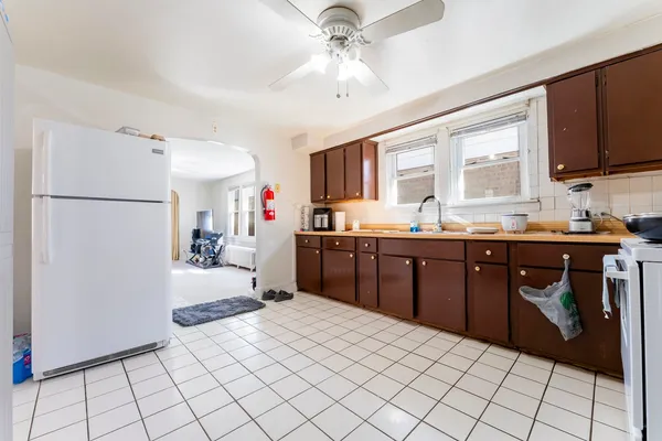 a kitchen with a sink a stove cabinets and a dining table