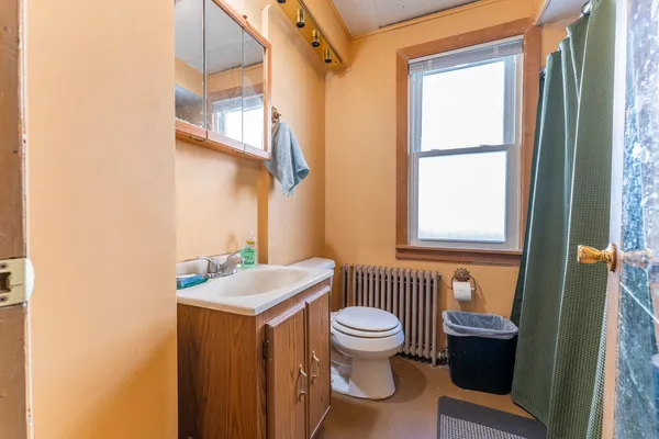 a bathroom with a toilet sink and mirror