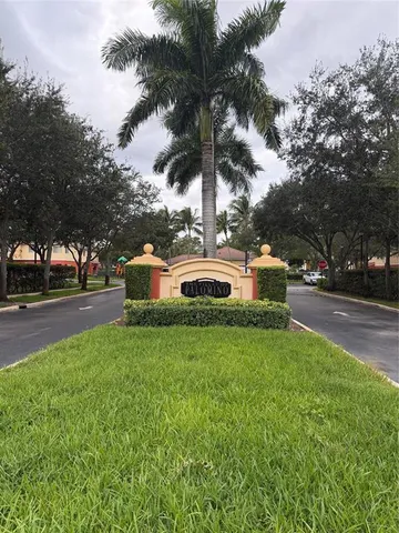 a front view of a house with a garden and tree