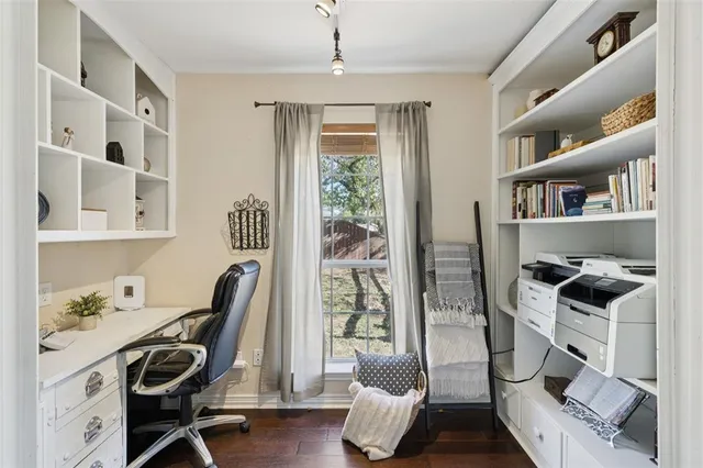 a view of a workspace with furniture and a window