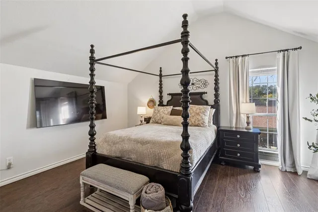 a bedroom with a bed and a flat tv screen on a dresser