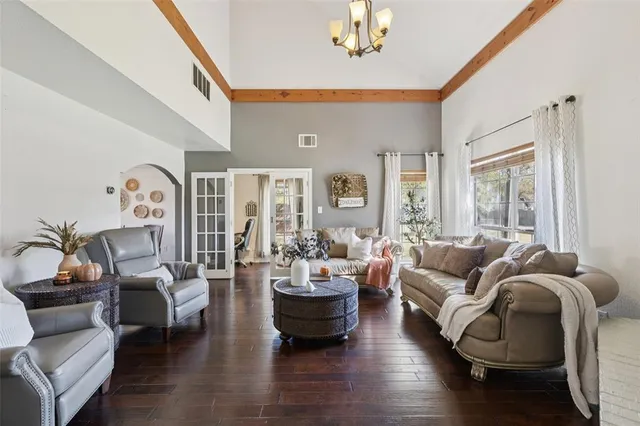 a living room with furniture large window and wooden floor