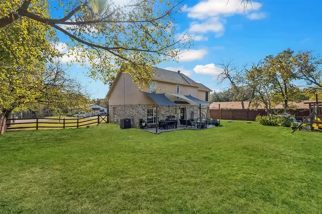 a yellow house sitting in middle of the grass