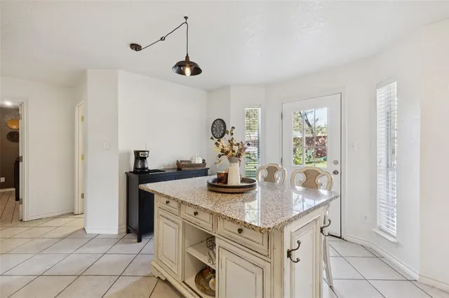 a kitchen with kitchen island granite countertop appliances cabinets and a counter top space