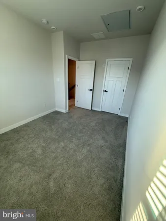 an empty room with staircase and white walls