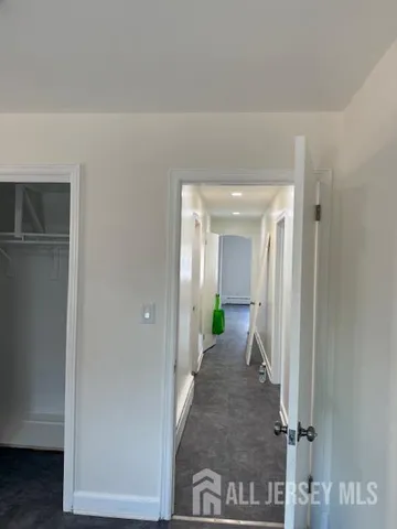 a view of a hallway with wooden floor and a living room