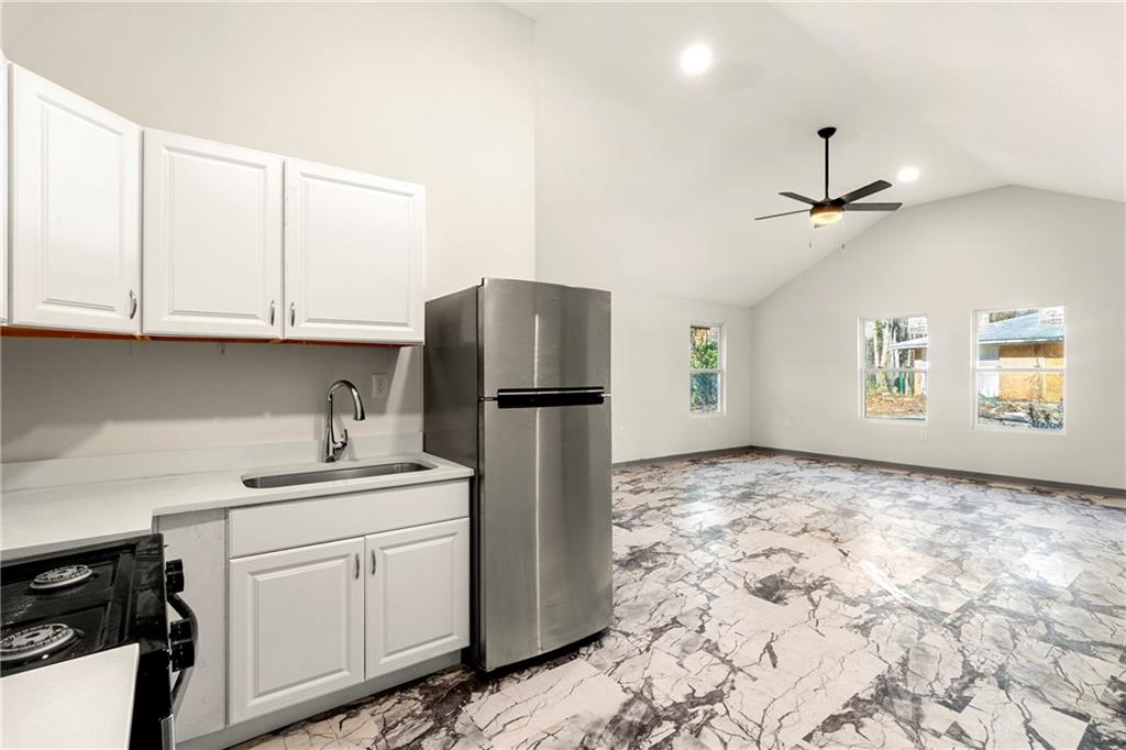 4010 Boulder Park Drive Southwest Atlanta, GA 30331 - Photo 3 of 8 a kitchen with kitchen island a refrigerator sink and cabinets