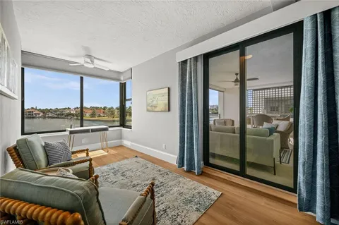 a living room with furniture and a floor to ceiling window