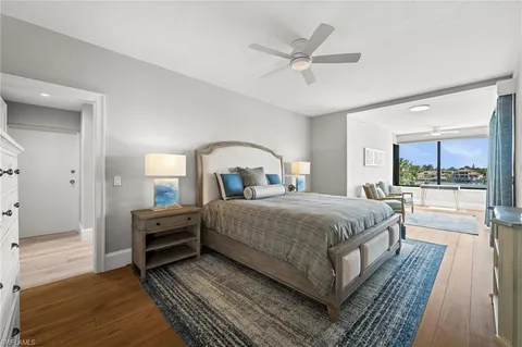 a spacious bedroom with a bed a mirror and lamp