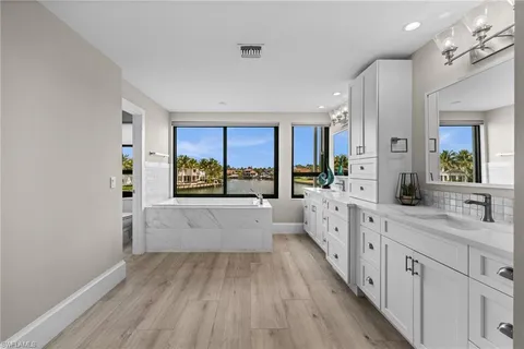 a large white kitchen with kitchen island a large counter space a sink and appliances