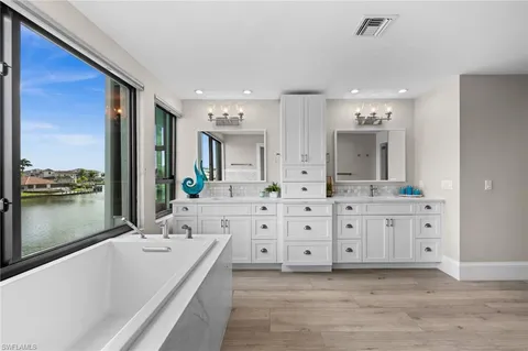 a bathroom with double vanity sink and a large mirror