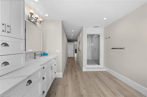 a bathroom with a double vanity sink and mirror with shower
