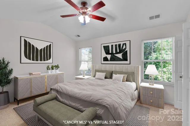 a bedroom with a large bed and a chandelier