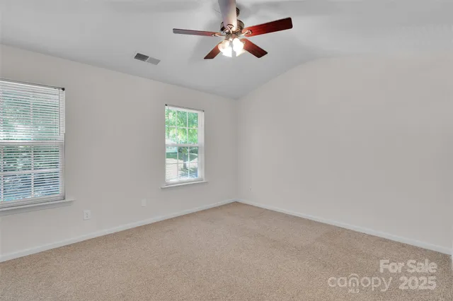 an empty room with a window and a fan