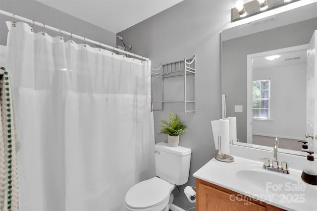 a bathroom with a granite countertop sink toilet and a mirror