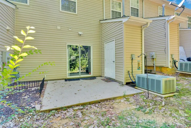 a view of a backyard with chairs and potted plants