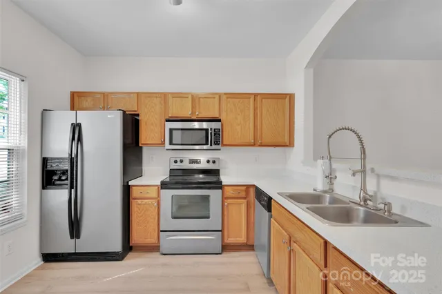 a kitchen with stainless steel appliances granite countertop a sink stove and refrigerator