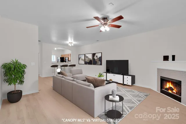 a living room with furniture a fireplace and a potted plant