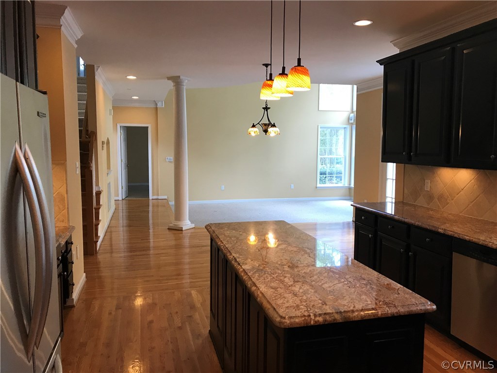 11812 Club Ridge Drive Chester, VA 23836 - Photo 8 of 36 a kitchen with granite countertop a refrigerator a stove and a sink with wooden floor