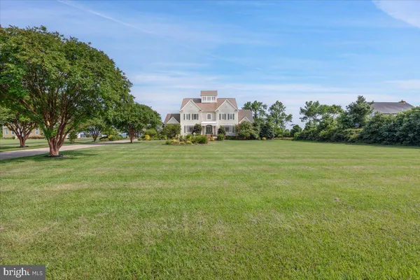 a view of a lake with a big yard and large trees