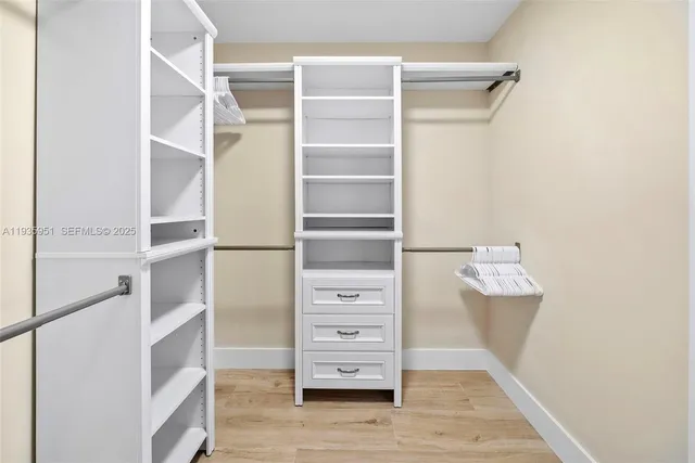 a view of walk in closet with empty racks