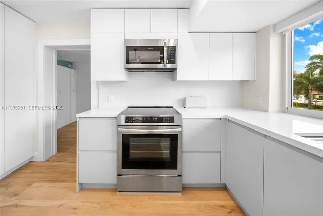 a kitchen with stainless steel appliances granite countertop a stove a microwave and a sink