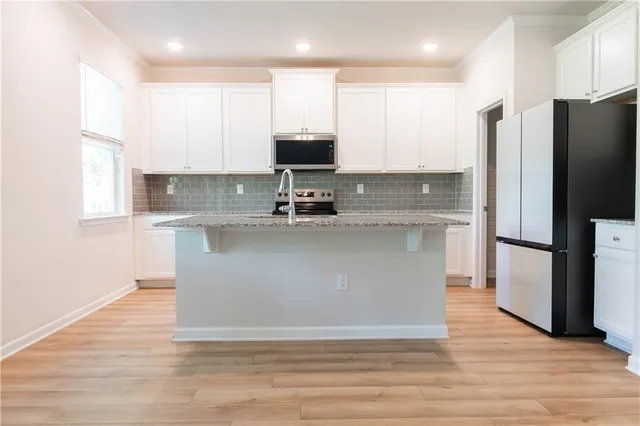 a view of a kitchen with stainless steel appliances granite countertop a stove a refrigerator and a sink