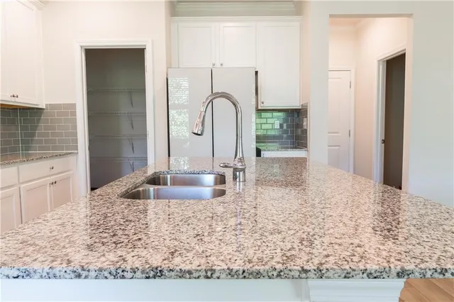 a kitchen with sink a refrigerator and faucet