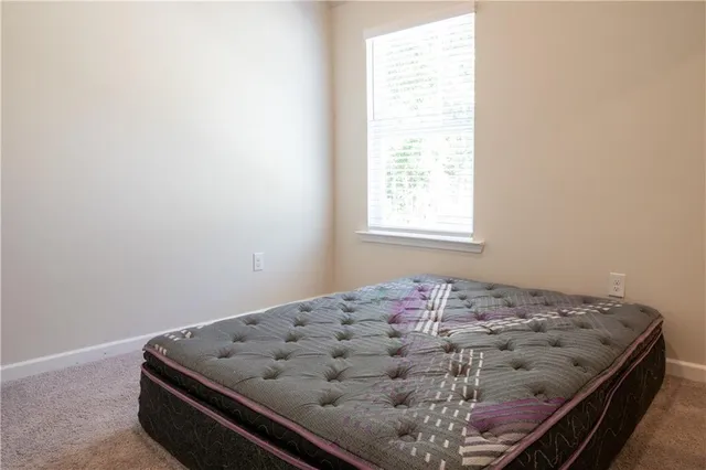 a bed sitting in a bedroom next to a window
