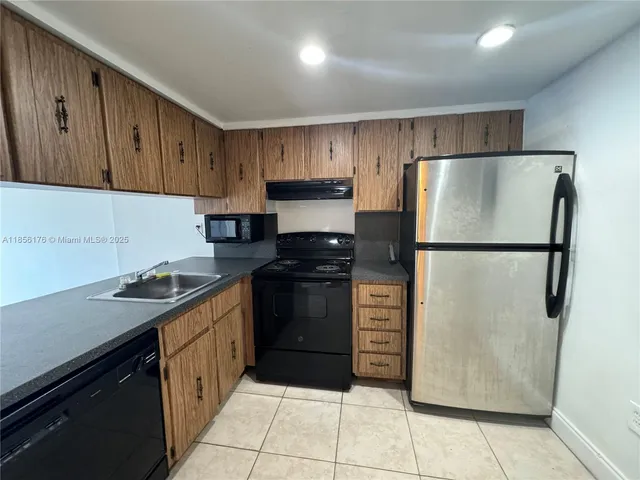 a kitchen with a refrigerator sink and cabinets