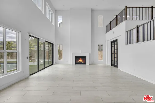 a view of an empty room with a fireplace and a window