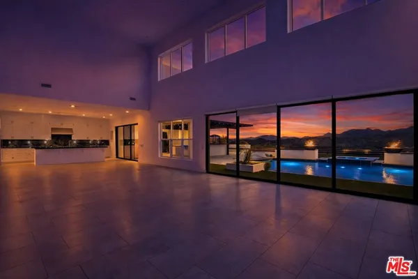 a view of swimming pool with a table and chairs under an umbrella