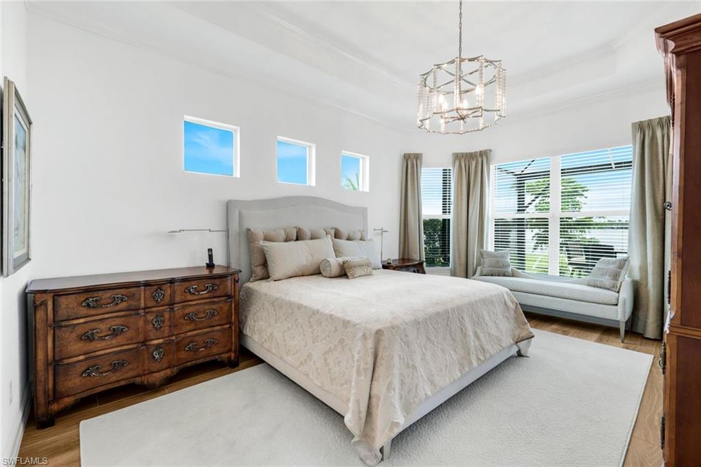 14630 Blue Bay Circle Fort Myers, FL 33913 - Photo 13 of 49 a bedroom with a large bed and a chandelier